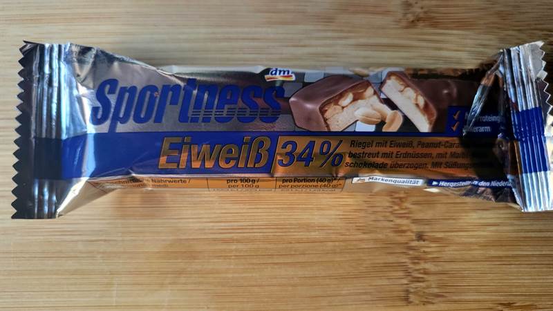 dm Sportness Eiweiß 34% Arachidi e caramello ricoperta di arachidi e cioccolato al latte